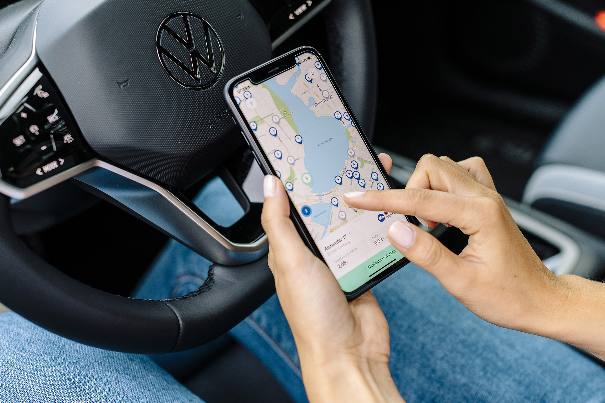Eine Hand bedient eine Navigationsoftware auf einem Handydisplay