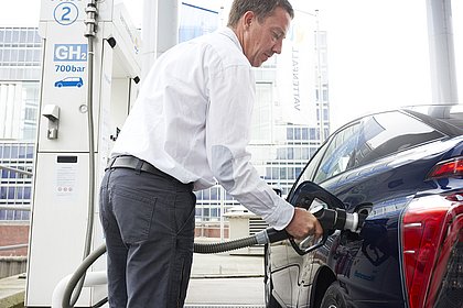 Ein Mann tankt einen Wasserstoff-Pkw auf