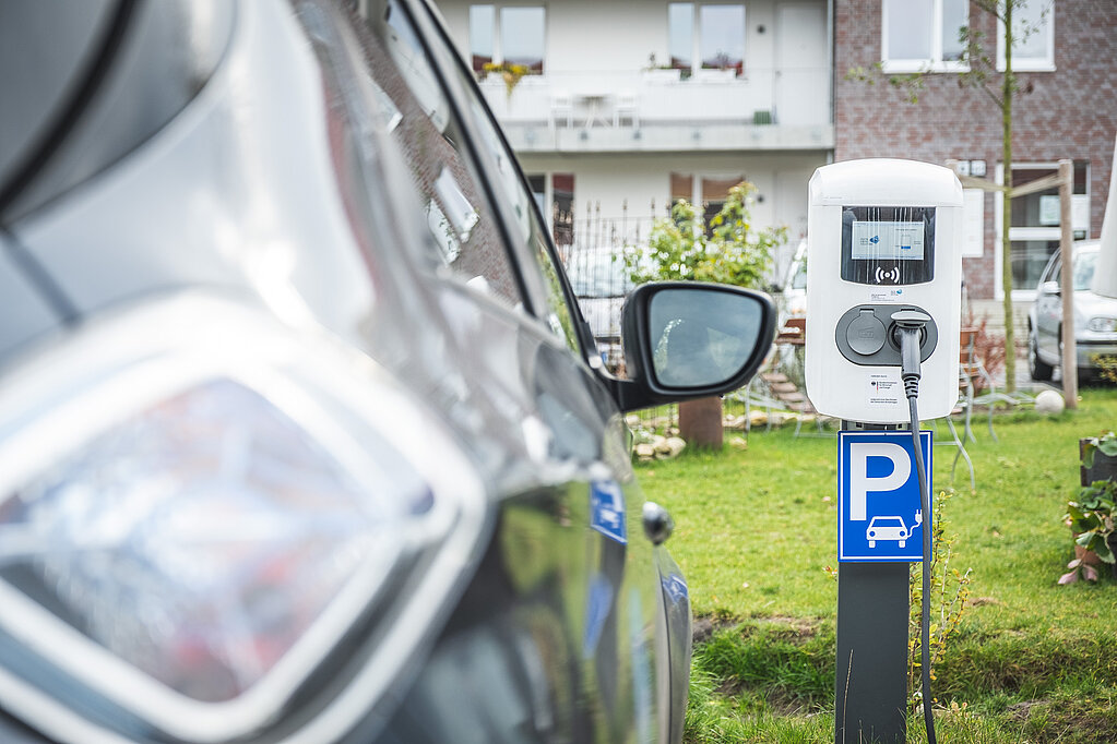 Öffentliche Ladesäule, daneben ein graues Auto